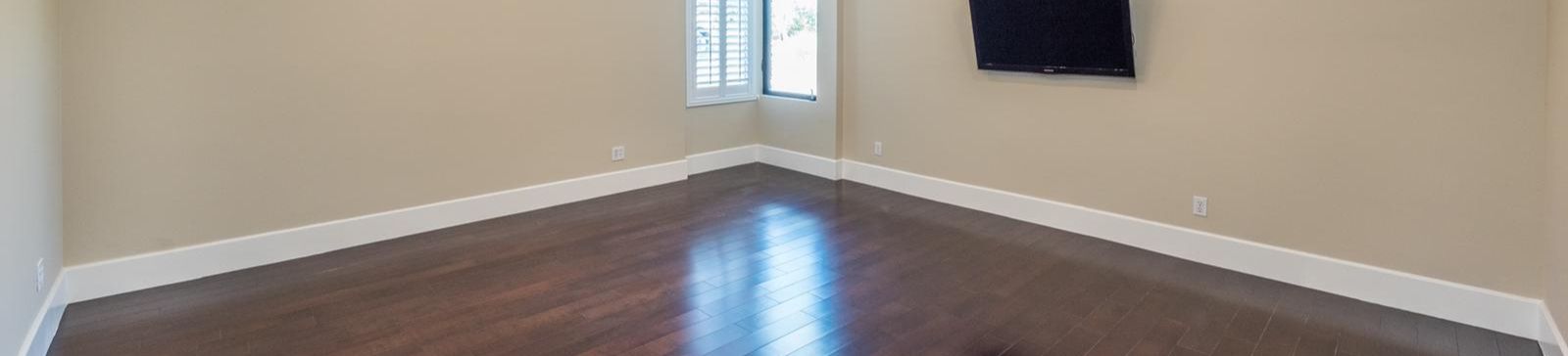 Spacious Whittier living area featuring new hardwood flooring, large window, and fresh neutral walls after professional remodeling.