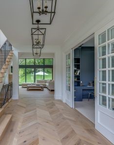 Modern stairway with custom wood treads, sleek black iron railings, and floor-to-ceiling windows in a remodeled South Whittier home.