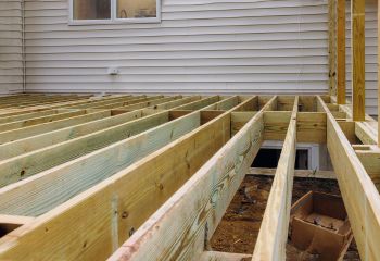 Close-up view of new wooden deck framing installed for a Santa Fe Springs patio, showing sturdy pressure-treated lumber.